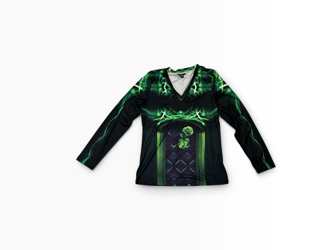 A long-sleeve athletic top laid flat on a light gray background, featuring a black base with a vibrant green and dark purple graphic print.